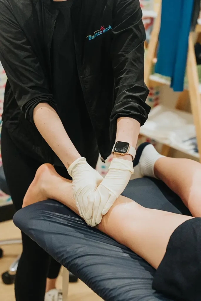 physio assessing calf muscle on patient