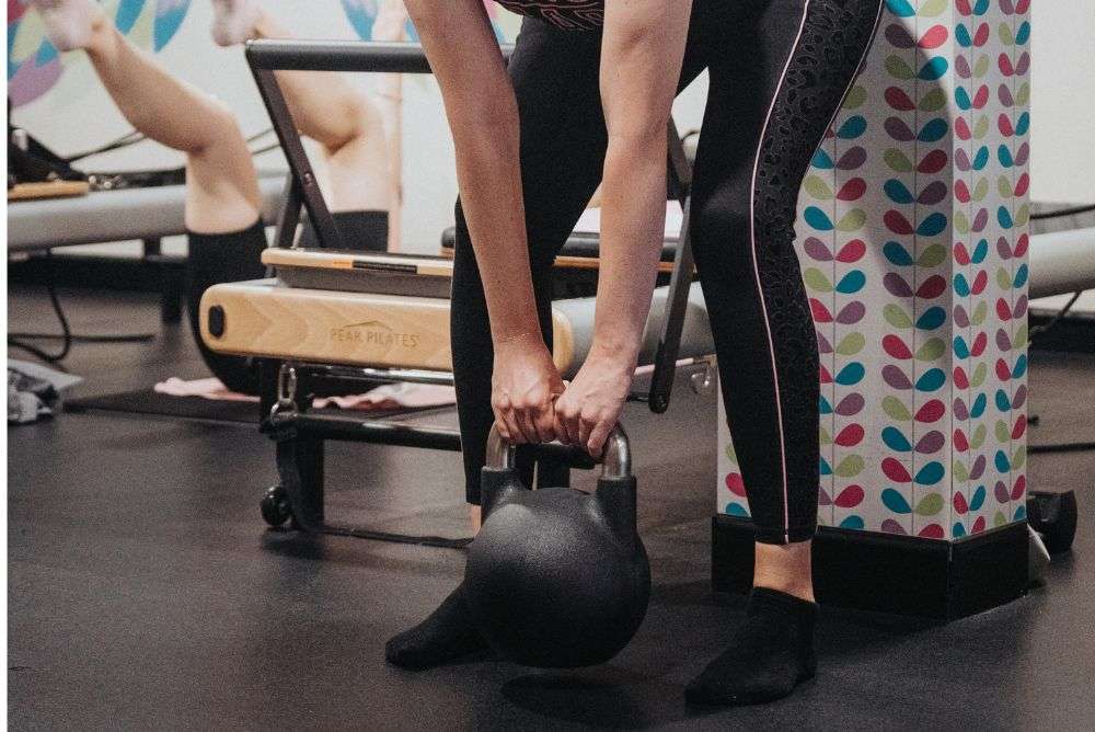 woman deadlifting kettlebell