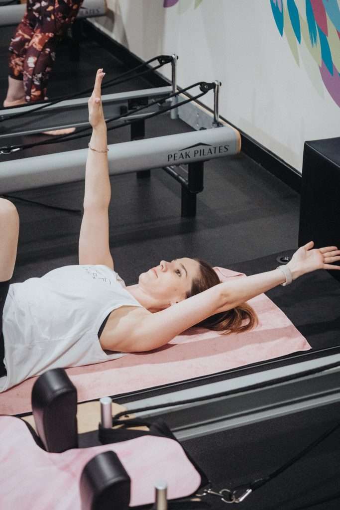woman doing pilates on reformer machine